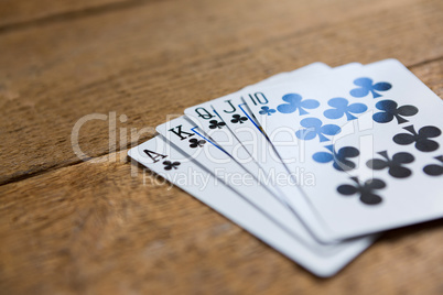 Close-up of clubs cards on wooden table