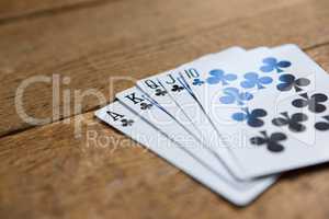 Close-up of clubs cards on wooden table
