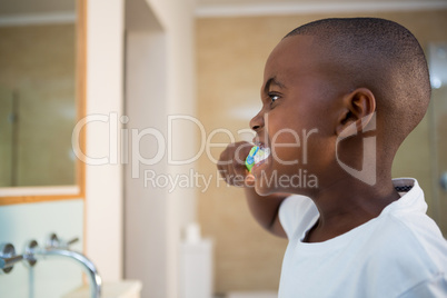 Side view of boy brushing teeth
