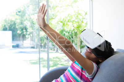 Girl gesturing while wearing virtual reality simulator at home