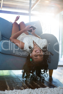 Upside down portrait of girl relaxing on armchair