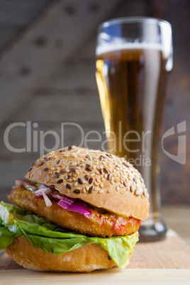 Burger with glass of beer on chopping board