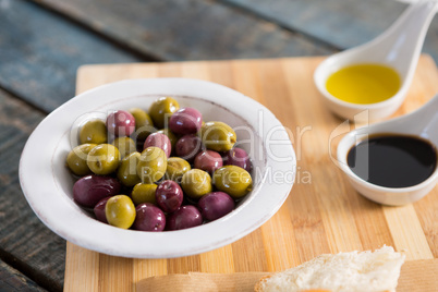 Marinated olives with olive oil on chopping board