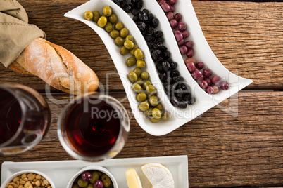 Close-up of marinated olives with glasses of wine