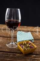 Close-up of marinated olives with glass of wine