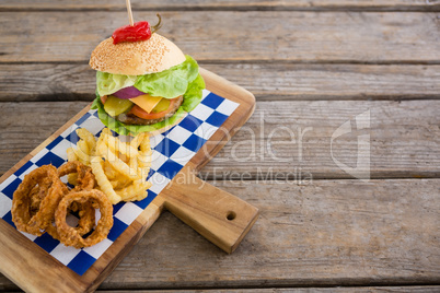 High angle view of onion rings and french fries with burger