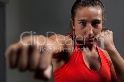 Determined woman practicing boxing in fitness studio