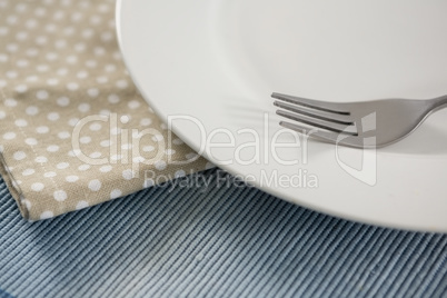 Close up of empty plate with fork and napkin