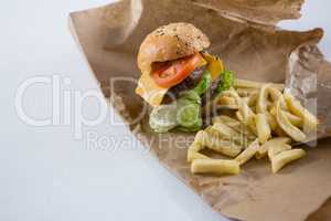 High angle view of burger and French fries on paper