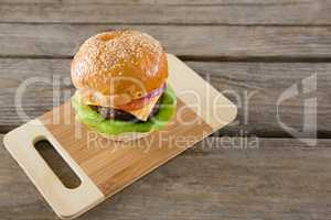 High angel view of hamburger with cheese on cutting board