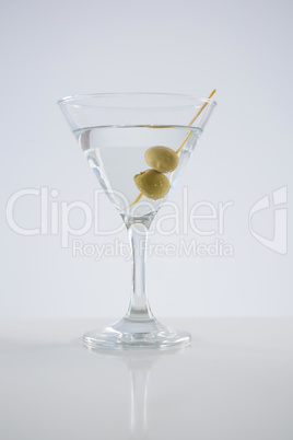 Cocktail martini with olives on table