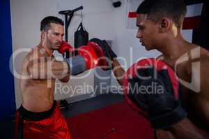 Trainer assisting man in boxing