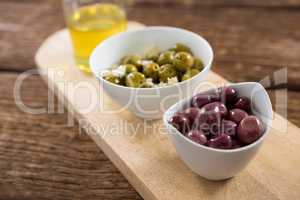 Marinated olives in bowl on chopping board