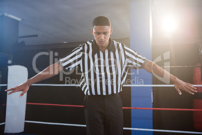 Male referee gesturing with arms outstretched