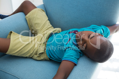High angle view of boy sleeping on blue armchair at home