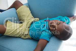 High angle view of boy sleeping on blue armchair at home