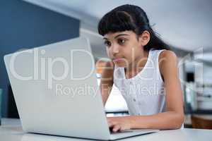 Girl using laptop in kitchen
