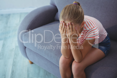 High angle view of girl with hands covering face