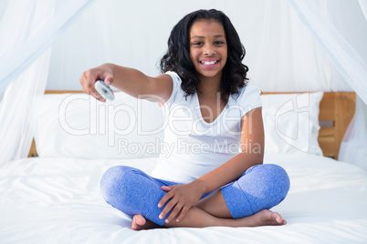 Portrait of happy girl holding remote control