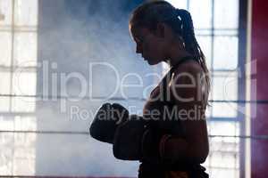 Determined woman standing in boxing ring