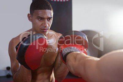 Trainer assisting man in boxing