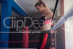 Thoughtful woman standing in boxing ring