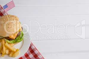 Burger decorated with american flag and french fries in plate
