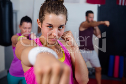 Portrait of young female practicing boxing against flags