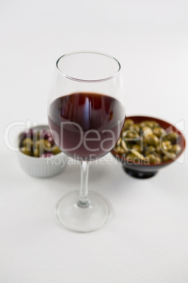 Close-up of marinated olives with glass of wine