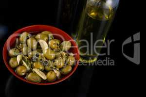 Close-up of marinated olives with olive oil and balsamic vinegar bottle