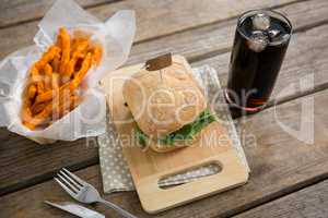 Burger with french fries and drink on table