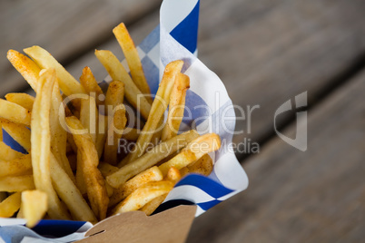 Close up of French fries with wax paper in container