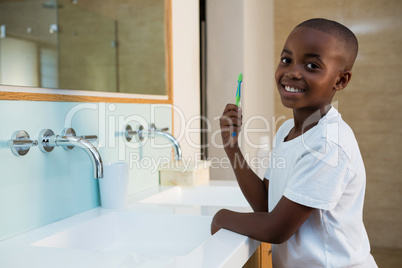 Side view of portrait of smiling boy with toothbrush