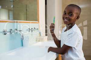 Side view of portrait of smiling boy with toothbrush