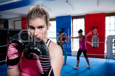 Young female boxer standing in ring