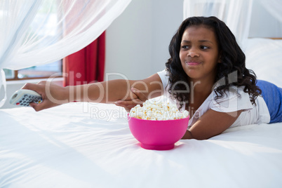 Girl changing channel while watching television
