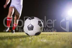 Low section of soccer player and ball on field