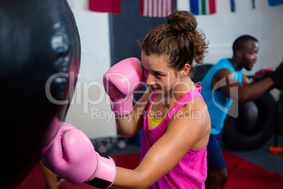 Young female boxer punching bag
