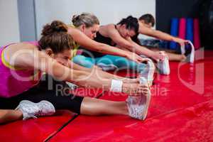 Row of young athletes practicing stretch exercise