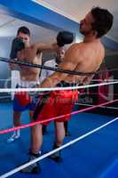 Young boxer punching male competitor