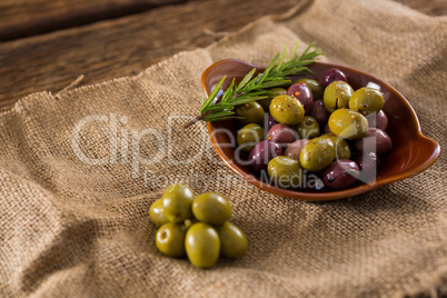 Marinated olives with herbs on burlap