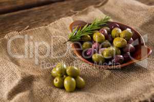 Marinated olives with herbs on burlap