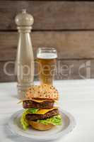 Close-up of hamburger in plate with glass of beer