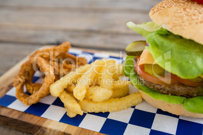 Close up of onion rings and french fries with burger