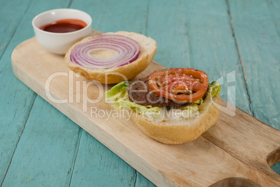 Close-up of hamburger and sauce on chopping board