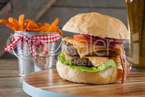 Hamburger and french fries on chopping board