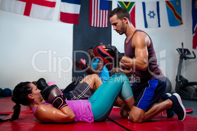 Instructor assisting female boxer