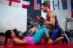 Instructor assisting female boxer