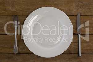 White plate with cutlery on table