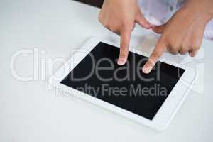 High angle view of girl touching fingers on digital tablet